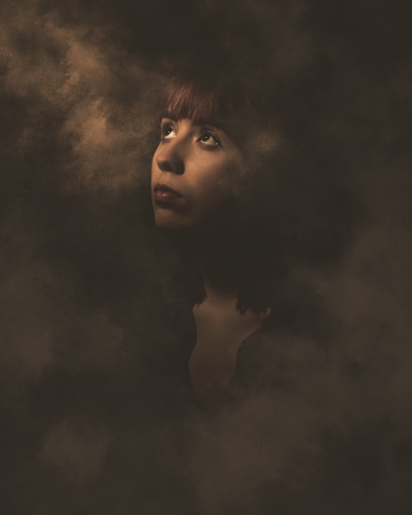 Woman surrounded by ethereal smoke.